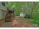 View of the backyard with lush greenery and a detached storage shed at 160 Kingfisher Dr, Mooresville, NC 28117