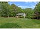 Expansive backyard featuring a well-manicured lawn, mature trees, and charming single-story home at 160 Kingfisher Dr, Mooresville, NC 28117