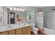 Well-lit bathroom featuring a double sink vanity, decorative mirror, and a shower-tub combination at 160 Kingfisher Dr, Mooresville, NC 28117