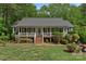 Inviting single-story home featuring a classic front porch, complemented by lush greenery and a well-maintained lawn at 160 Kingfisher Dr, Mooresville, NC 28117