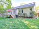 Spacious backyard featuring a deck with colorful umbrellas and well-maintained lawn and landscaping at 1715 Colin Creek Ln, Charlotte, NC 28214