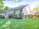 Well-manicured backyard featuring a deck with colorful umbrellas, and a charming garden area with roses at 1715 Colin Creek Ln, Charlotte, NC 28214