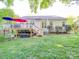 Spacious backyard featuring a wooden deck, stairs to yard, lush green grass, and mature trees at 1715 Colin Creek Ln, Charlotte, NC 28214