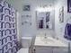 This cozy bathroom features a mirror, toilet, sink and patterned shower curtain at 1715 Colin Creek Ln, Charlotte, NC 28214