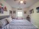 This comfortable bedroom is bathed in natural light, showcasing a cozy atmosphere with an overhead ceiling fan at 1715 Colin Creek Ln, Charlotte, NC 28214