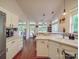 Well-lit kitchen boasts white cabinets, a breakfast bar, and views of the outdoor deck at 1715 Colin Creek Ln, Charlotte, NC 28214
