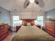 This spacious main bedroom features an olive green quilt, hardwood floors, and dual windows for tons of natural light at 1715 Colin Creek Ln, Charlotte, NC 28214