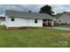 Charming single-story home featuring white siding and a covered carport, set on a lush green lawn at 2109 Boggs St, Lincolnton, NC 28092