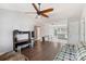 Bright living room with hardwood floors, vaulted ceiling with fan, and view into kitchen/dining area at 244 Whitesides Rd, Bessemer City, NC 28016