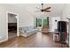 Well-lit living room featuring hardwood floors, a comfortable sofa, and an open doorway leading to the bedroom at 244 Whitesides Rd, Bessemer City, NC 28016