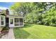 Beautiful backyard featuring a screened porch, lush green lawn, and mature trees at 2506 Breuster Dr, Charlotte, NC 28210