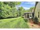 Spacious backyard with lush lawn, mature trees, and a charming screened-in porch at 2506 Breuster Dr, Charlotte, NC 28210