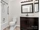 Bathroom with toilet, vanity with dark cabinets, and a shower/tub with a grab bar at 2506 Breuster Dr, Charlotte, NC 28210