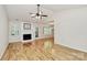 Bright living room featuring hardwood floors, fireplace, and access to the dining area at 2506 Breuster Dr, Charlotte, NC 28210