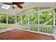 Spacious screened porch with wood flooring and views of the lush greenery outdoors at 2506 Breuster Dr, Charlotte, NC 28210
