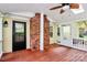 Bright sunroom featuring a brick fireplace, wood floors, white railings, and a ceiling fan at 2506 Breuster Dr, Charlotte, NC 28210