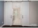 Bathroom with modern white sliding barn doors leading to double vanity, and glass enclosed shower at 286 Hemlock Bluff Ct, Denver, NC 28037