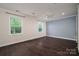 Spacious bedroom with hardwood floors, two large windows, and a statement wall at 286 Hemlock Bluff Ct, Denver, NC 28037