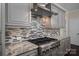 Elegant kitchen with a stainless steel range hood, custom tile backsplash, and granite countertops at 286 Hemlock Bluff Ct, Denver, NC 28037