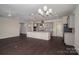Open-concept kitchen features gray cabinets, granite counters, and a spacious center island, seamlessly flowing into the living area at 286 Hemlock Bluff Ct, Denver, NC 28037