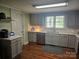 Well-lit kitchen with gray cabinets, stainless steel appliances and hardwood floors at 3100 Wallace Rd, Midland, NC 28107
