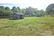Green backyard shed with wooden fence along the perimeter at 3100 Wallace Rd, Midland, NC 28107