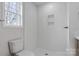 Clean white bathroom with shower, toilet, and window at 3315 15Th Sw Ave, Hickory, NC 28602