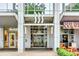 Modern building exterior featuring an entrance with unique design elements and commercial businesses at 333 W Trade St # 800, Charlotte, NC 28202