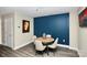 Cozy dining area with a round table, modern chairs and a vibrant blue accent wall at 333 W Trade St # 800, Charlotte, NC 28202
