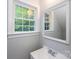 Bright bathroom featuring a sleek sink, large window, and a decorative framed mirror at 3546 Weddington Oaks Dr, Weddington, NC 28104