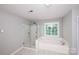 Luxurious bathroom featuring a glass shower, jacuzzi tub and natural light at 3546 Weddington Oaks Dr, Weddington, NC 28104
