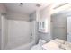 Bright bathroom featuring a white shower-tub combo, vanity, toilet, and built-in storage at 3546 Weddington Oaks Dr, Weddington, NC 28104