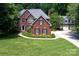 Stately two-story brick home with mature landscaping and a three-car garage at 3546 Weddington Oaks Dr, Weddington, NC 28104