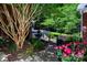 Manicured backyard featuring a beautiful garden, stone pavers, and a tranquil fountain at 3546 Weddington Oaks Dr, Weddington, NC 28104