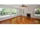Bright living room with a fireplace, hardwood floors and large windows providing plenty of natural light at 3546 Weddington Oaks Dr, Weddington, NC 28104