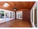 Bright sunroom featuring wood ceiling, skylight, fan, and walls of windows and brick wall at 3546 Weddington Oaks Dr, Weddington, NC 28104