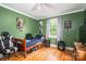 Bedroom displaying green walls, wood floors, and a ceiling fan at 400 Houser St, Cherryville, NC 28021