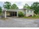 View of the side yard with a covered carport, gravel driveway and green shrubbery at 400 Houser St, Cherryville, NC 28021