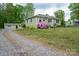 Charming home with green siding, surrounded by mature trees and landscaped yard at 400 Houser St, Cherryville, NC 28021