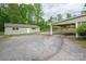 Exterior shot of the house showing a large gravel parking area and a covered carport at 400 Houser St, Cherryville, NC 28021