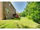 Spacious backyard with lush green grass, mature trees, and a wooden deck at 4704 Amberside Dr, Rock Hill, SC 29732