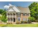 Charming two-story brick home featuring a double-decker porch and well-manicured lawn and landscape at 4704 Amberside Dr, Rock Hill, SC 29732