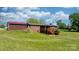Home's backyard with lush lawn, wooden deck, and detached garage at 4815 Rifle Range Rd, Conover, NC 28613