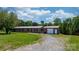 A well-maintained brick home featuring a detached garage, metal roof, and large lawn at 4815 Rifle Range Rd, Conover, NC 28613