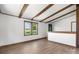 Light-filled living room with exposed beams, wooden floor and windows offers a welcoming space to relax and unwind at 4815 Rifle Range Rd, Conover, NC 28613
