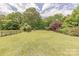 Expansive, well-maintained backyard surrounded by mature trees and a black metal fence, offering privacy and space at 5707 Parkstone Dr, Matthews, NC 28104