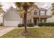 Charming two-story home with stone accents, a well-manicured lawn, and a two-car garage at 5707 Parkstone Dr, Matthews, NC 28104