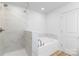 Bright bathroom featuring a soaking tub, stand-up shower, and modern tile at 601 Westway Dr, Gastonia, NC 28054