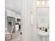 Modern bathroom with sleek pedestal sink, gold-trimmed mirror, and adjacent view into the kitchen at 601 Westway Dr, Gastonia, NC 28054