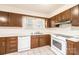 Functional kitchen featuring tiled floor, wood cabinets, and white appliances at 602 W 6Th St, Newton, NC 28658
